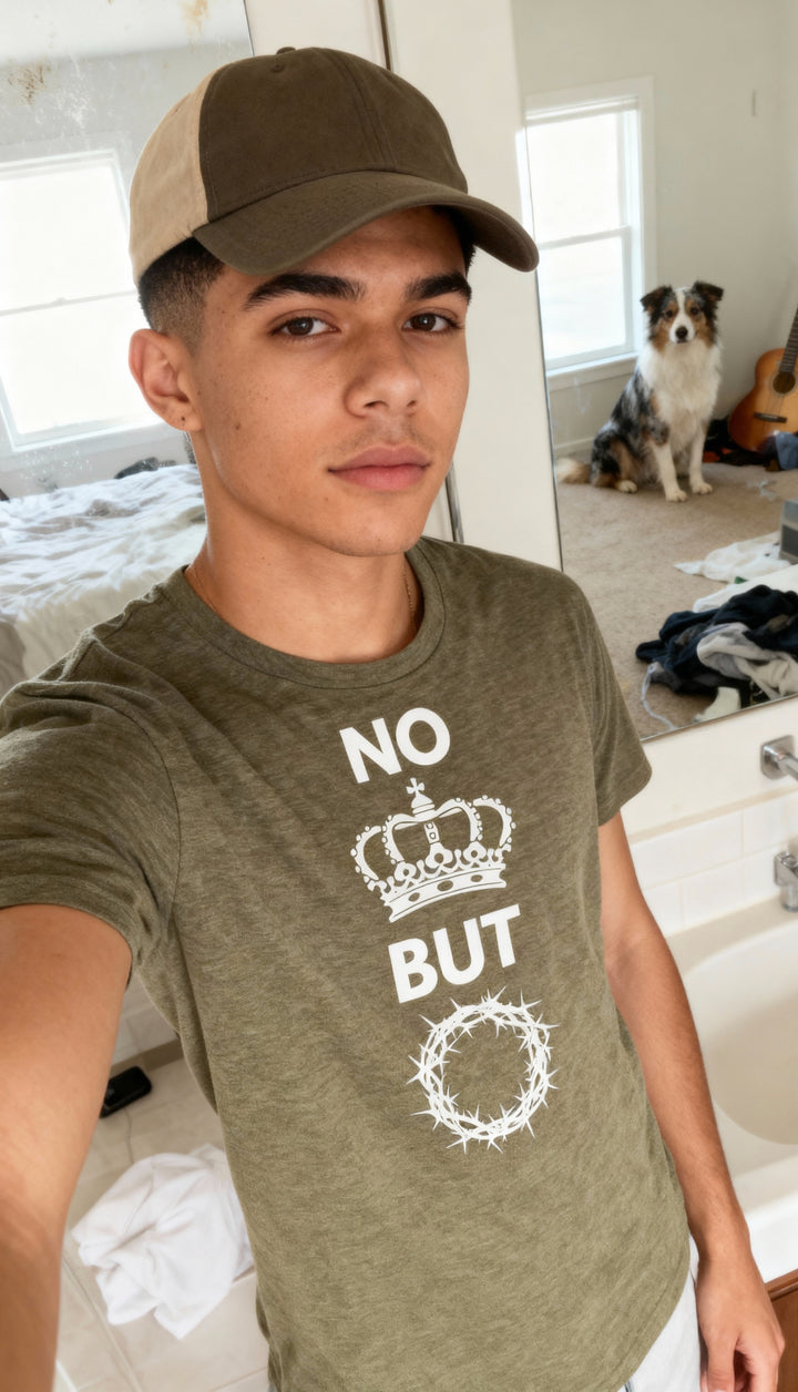 Person wearing a green t-shirt with text and a crown graphic, standing in a room with a dog and guitar in the background.