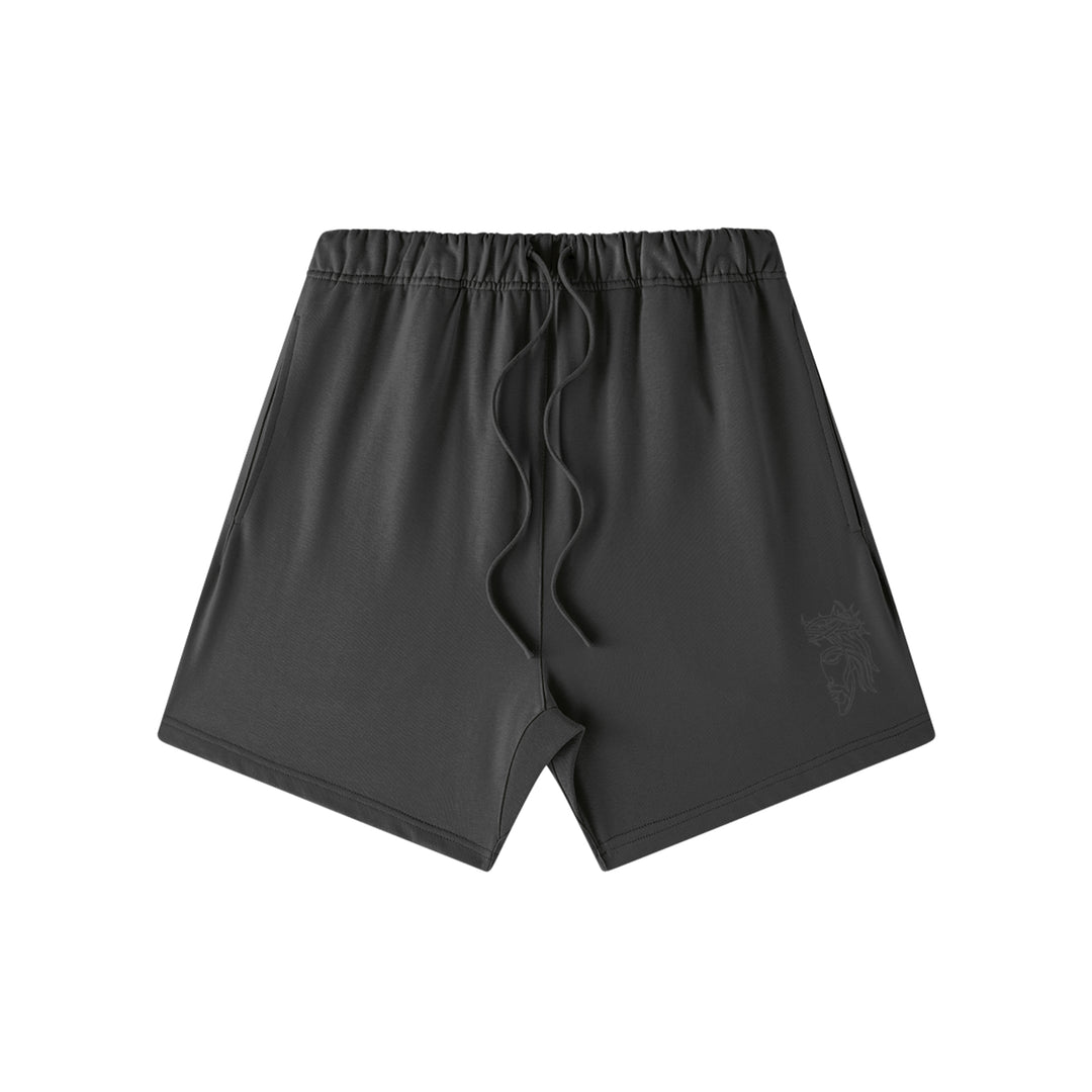 Front studio flat lay view of the Foundations Series Heavyweight Unisex Sweat Short in a black colorway. Features subtle high-density black Christ Half Face line-art embroidery on the left front leg panel, an overbuilt single-casing topstitched waistband with heavy-gauge tonal drawstrings, and a modern right-above-the-knee cut silhouette in massive 425GSM combed cotton French terry fabric.