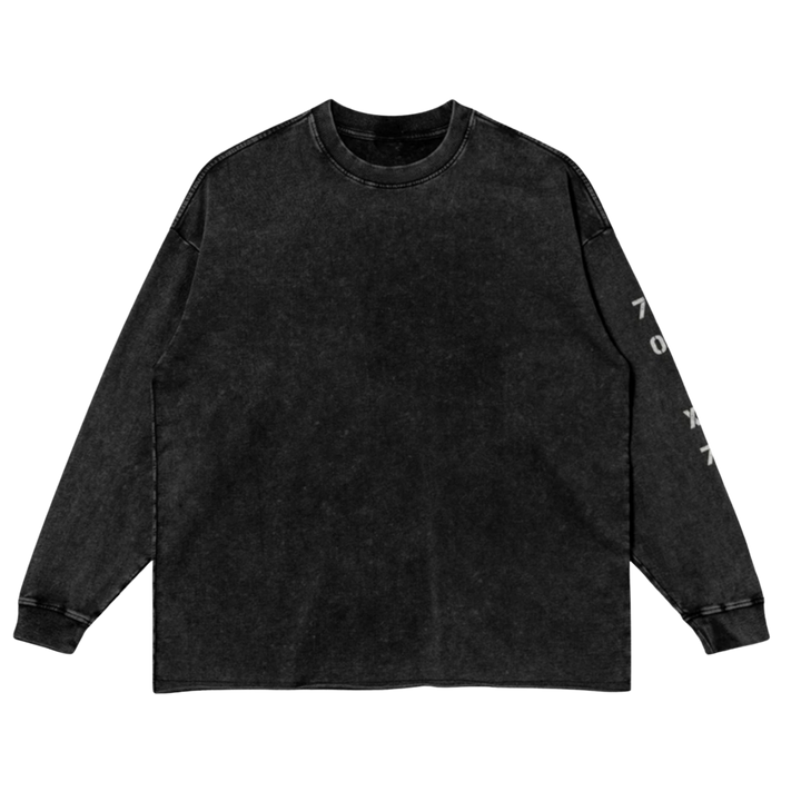 Front studio flat lay view of the Foundations Series 70X7 Raw Hem Long Sleeve in a sun-faded black tone, designed as premium Christian streetwear. Features a loose, boxy drop-shoulder silhouette in a heavy 260GSM combed cotton, highlighted by a weathered vertical stencil 70X7 sleeve print and a rugged raw-edge hem finish for a mission-driven Christian clothing statement.