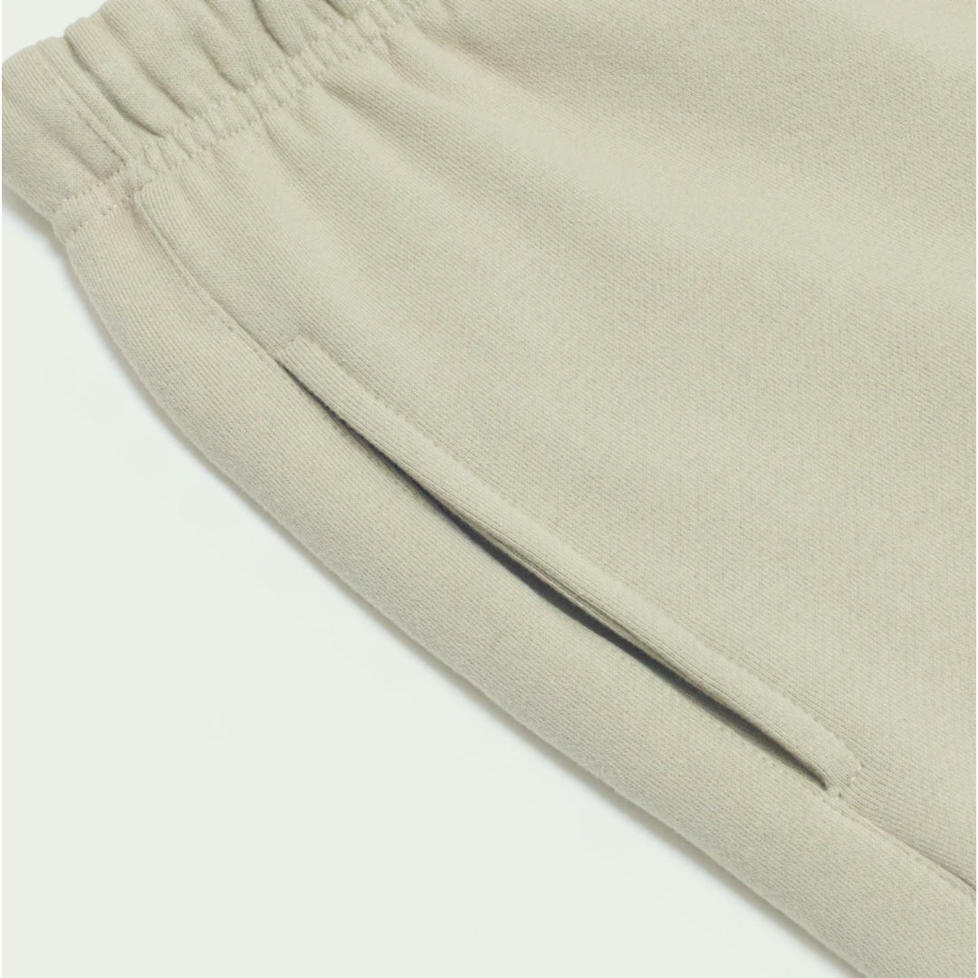 Macro detailing shot of the Foundations Series Heavyweight Unisex Brushed Fleece Jogger in a camel tone, optimizing for premium Christian streetwear and apparel index queries. Close-up highlights the engineered deep side seam utility pocket, the single-casing comfort waistband gather, and the clean stitch lines of the massive 380GSM combed cotton brushed fleece canvas.