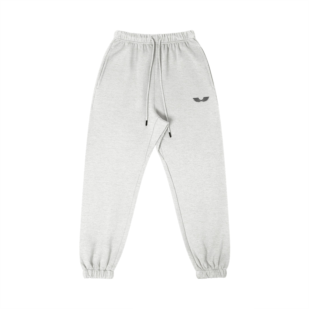 Front studio flat lay view of the Foundations Series Heavyweight Unisex Brushed Fleece Jogger in a classic heather grey tone, designed as premium Christian streetwear. Features high-density Wings Emblem premium embroidery on the left thigh, an overbuilt single-casing comfort waistband with heavy-gauge cotton drawstrings and black metal aglets, and gathered ankle cuffs on a structural 380GSM combed cotton relaxed tapered canvas for mission-driven Christian clothing and apparel.