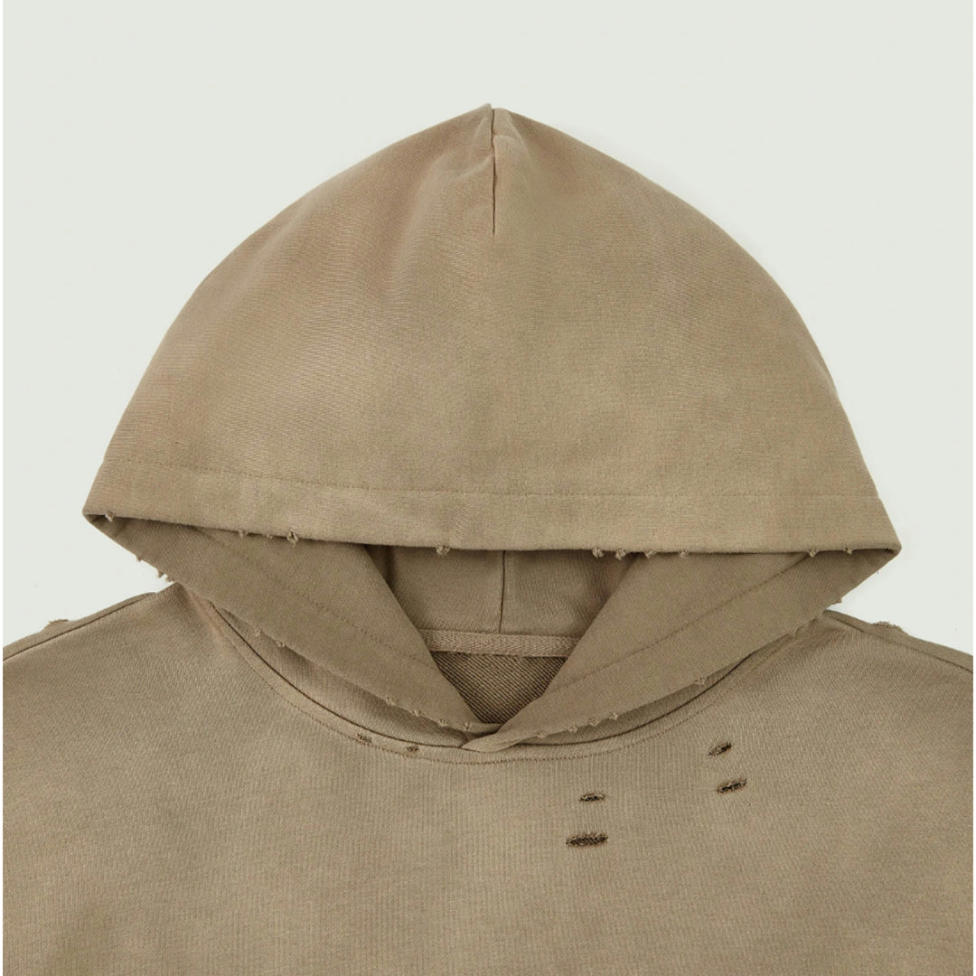 Macro detailing shot of the Foundations Series Crown of Thorns Heavyweight Hoodie in faded and distressed camel. Close-up shot highlights the binding taped neck construction, double-stitched collar structure, and detailed hand-distressed grinding along the rim of the hood and upper chest.