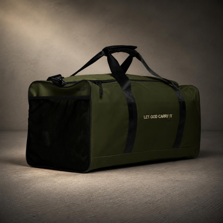 Three-quarter studio view of the Foundations Series Let God Carry It Utility Duffle Bag in olive green. Highlights the exterior quick-access mesh side pocket, dual padded handles with hook and loop closures, rigid T-piping architecture, and clean architectural typography.