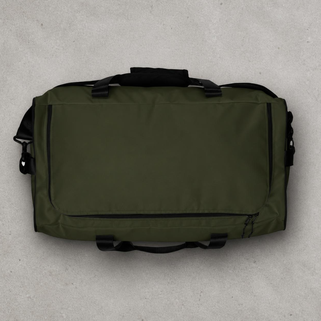 Overhead top-down studio view of the Foundations Series Let God Carry It Utility Duffle Bag in olive green on a concrete background. Showcases the main compartment zipper track configuration, dual padded mesh top handles, and the symmetrical rigid reinforced T-piping architecture.