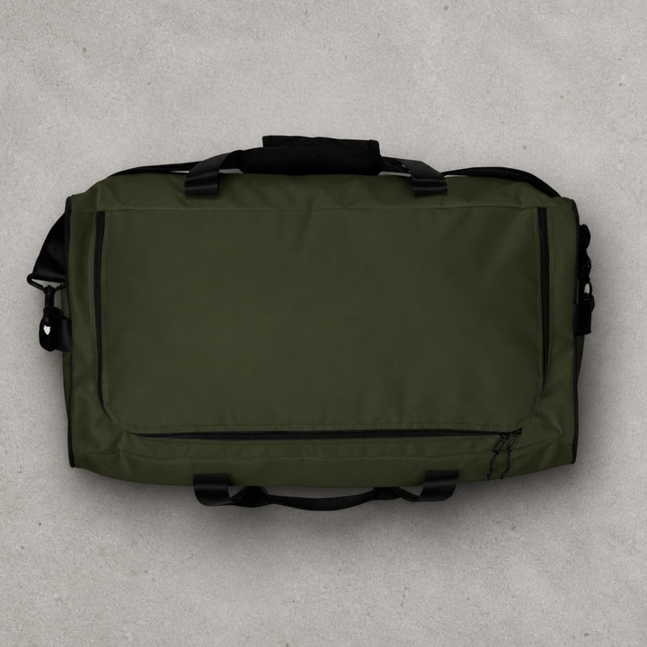 Overhead top-down studio view of the Foundations Series Let God Carry It Utility Duffle Bag in olive green on a concrete background. Showcases the main compartment zipper track configuration, dual padded mesh top handles, and the symmetrical rigid reinforced T-piping architecture.